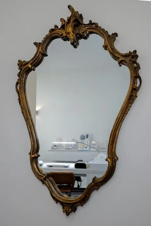 Een gouden spiegel aan de muur van de salon