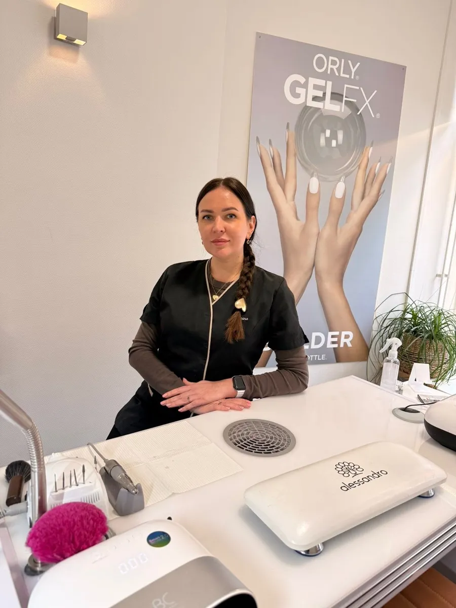 Yanina aan haar nageltafel in de salon